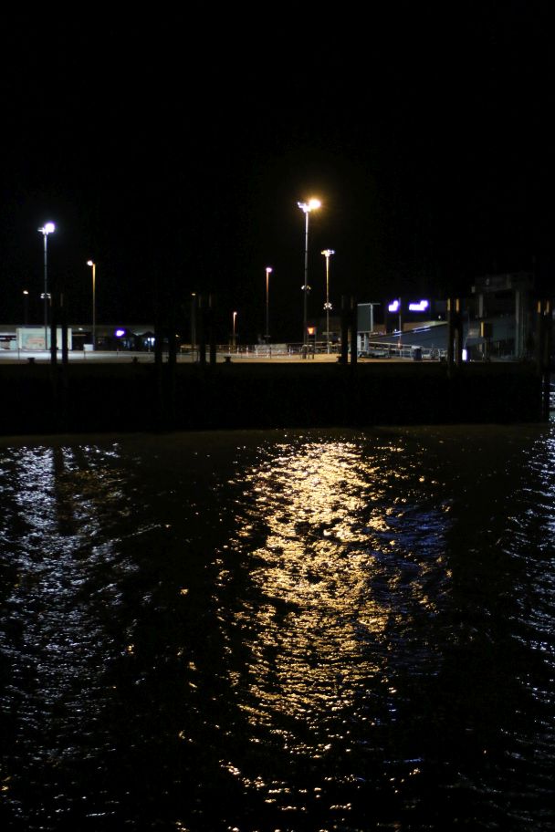 Hafenbeleuchtung, die auf das Wasser scheint.